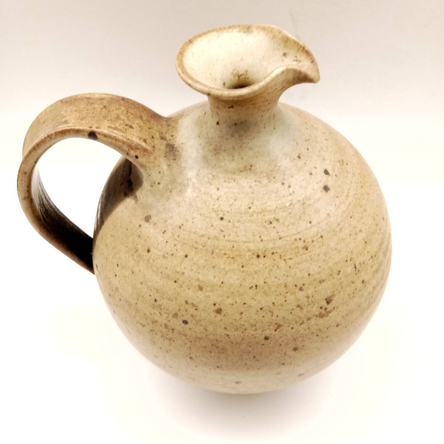 Vintage speckled brown stoneware jug in a round shape.
