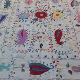 White suzani kilim rug with hand embroidered multi-colored patterns