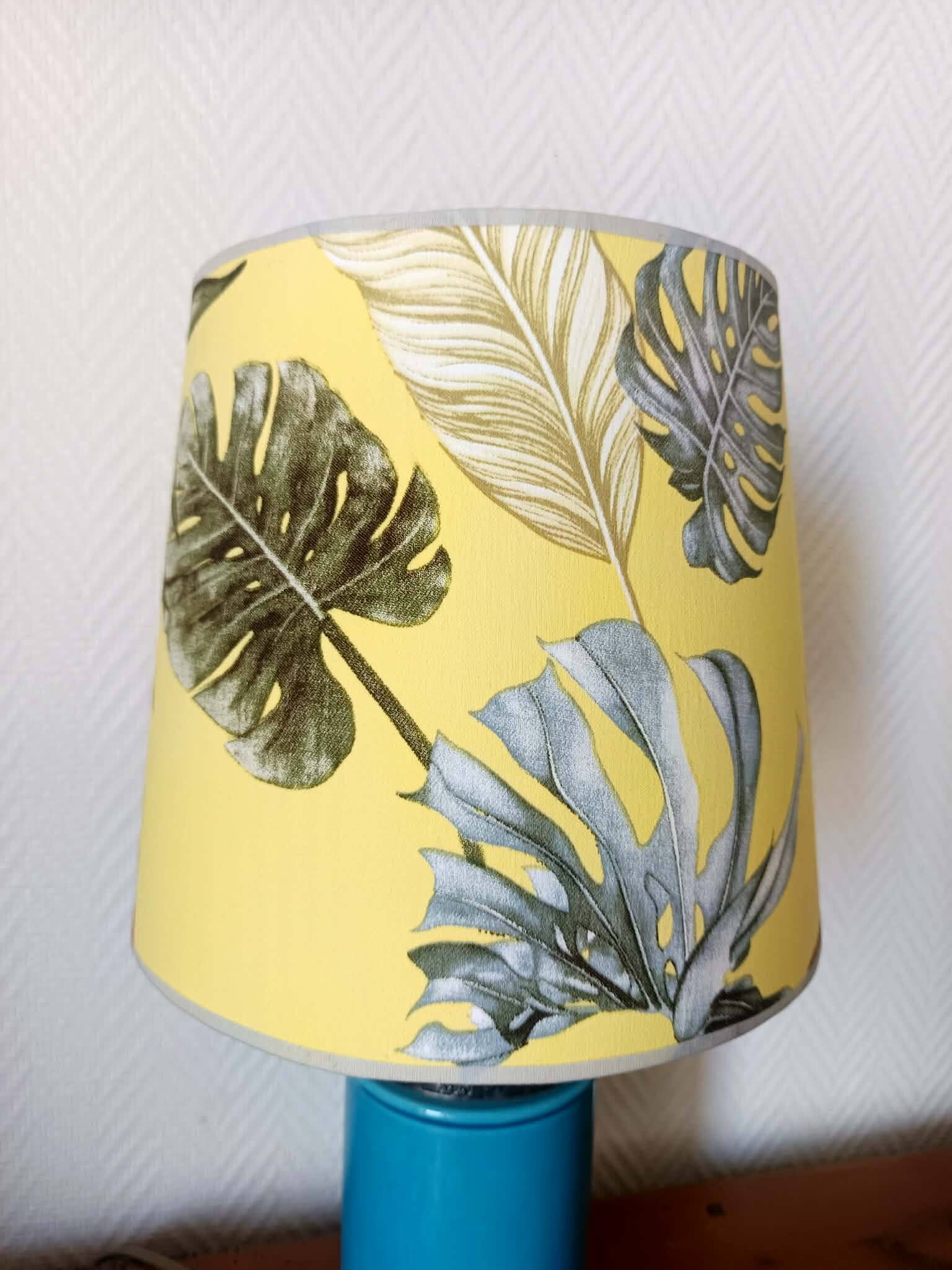 Blue ceramic lamp with claw feet and foliage lampshade.