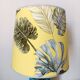 Blue ceramic lamp with claw feet and foliage lampshade.