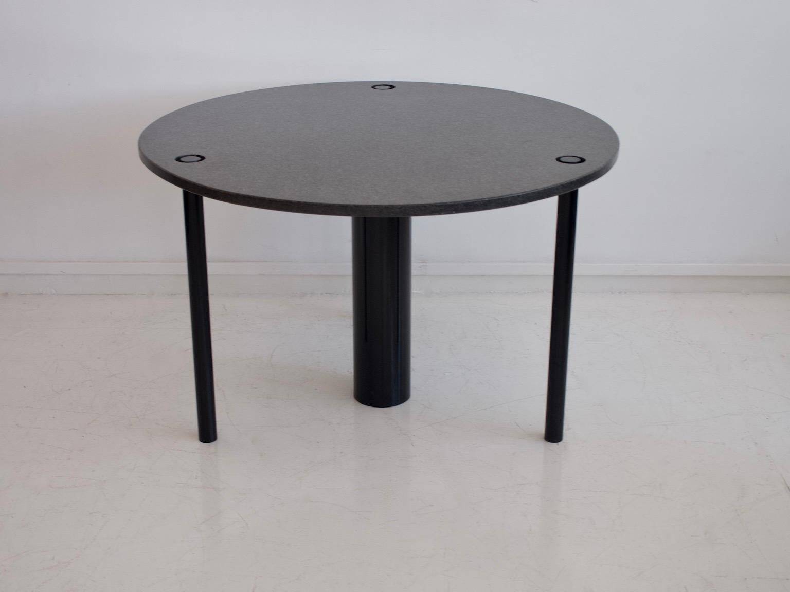Round dining table in black lacquered metal with a granite top.