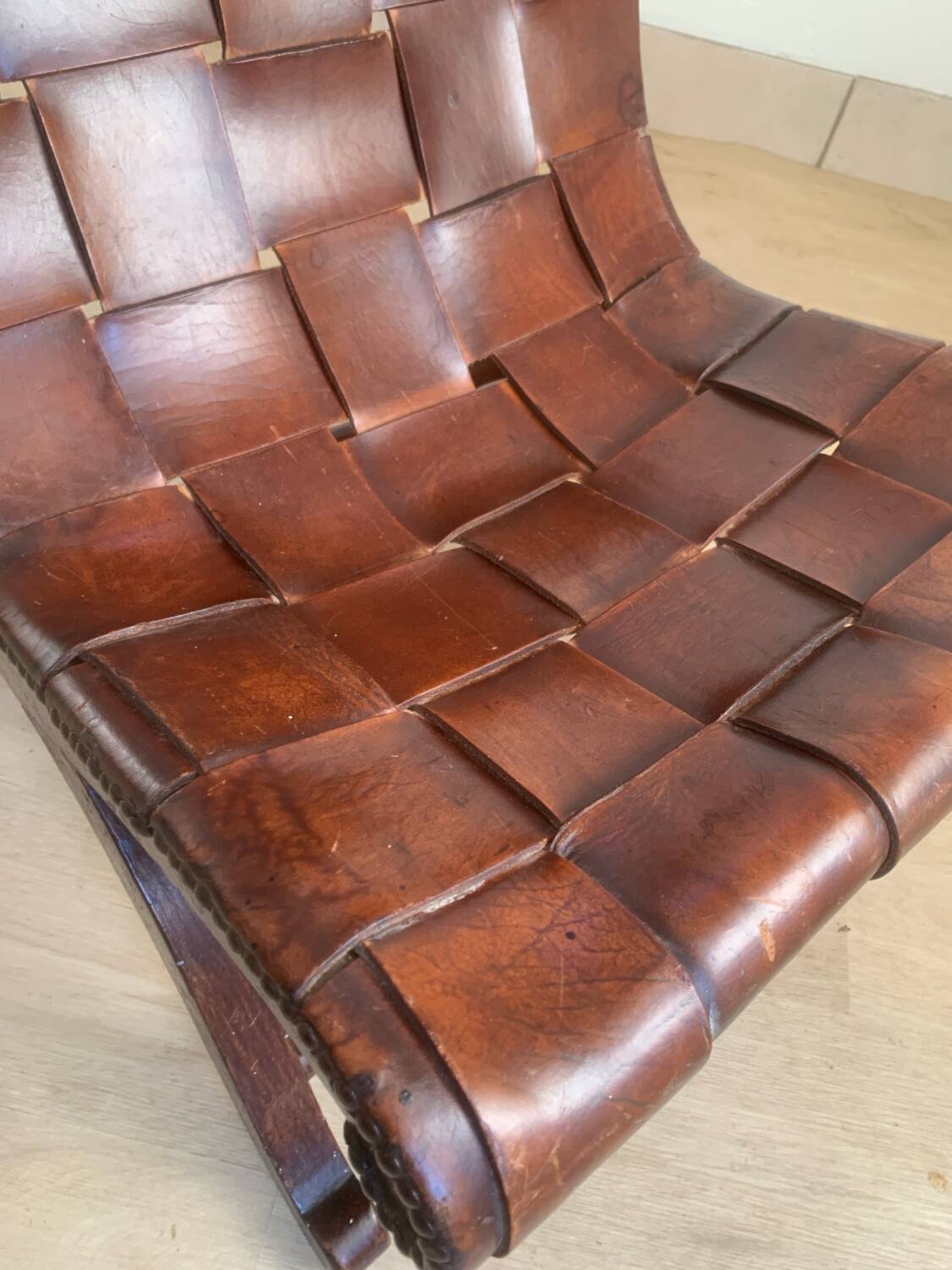 Chauffeuse en bois et cuir de Pierre Lottier