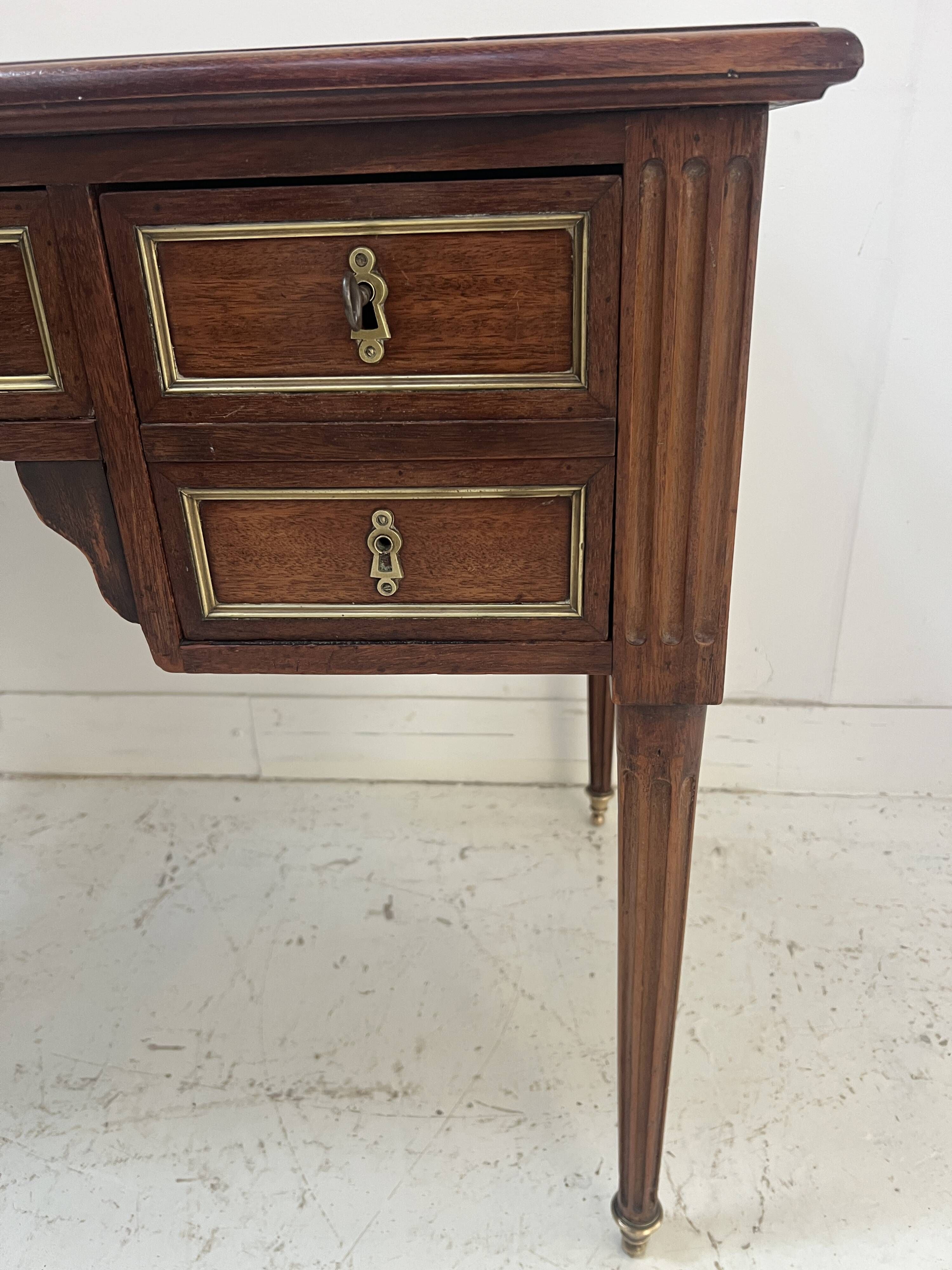 Louis XVI style desk in mahogany and mahogany veneer, 20th century.