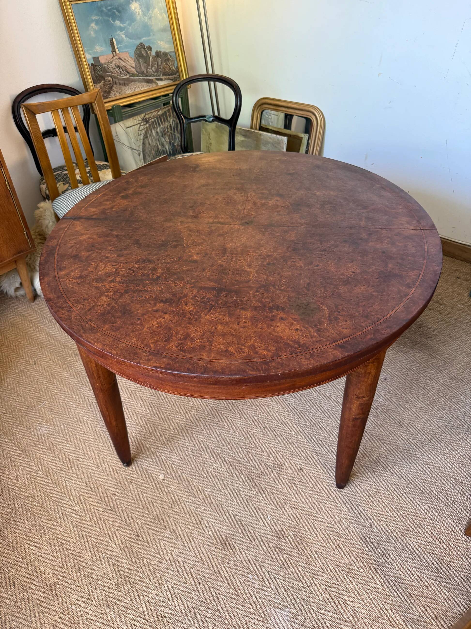 Oval extendable dining table in wood and walnut burl veneer.