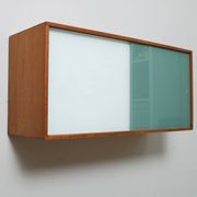 A vintage mid century wall hung bookcase/cabinet with glass sliding doors