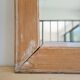 Antique mirror in raw wood with a patina and pediment.