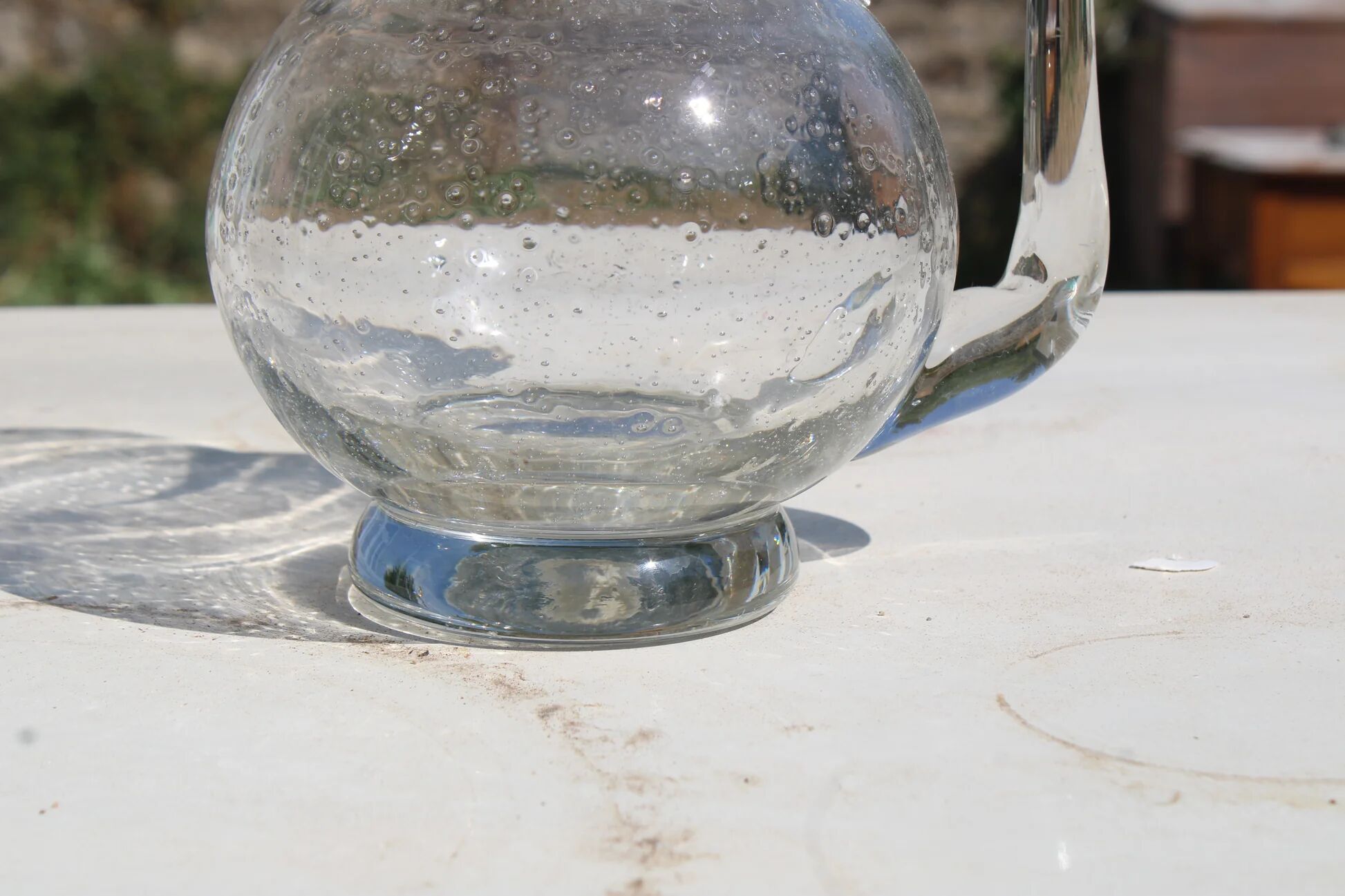 Vintage blown glass pitcher with bubbles, transparent.