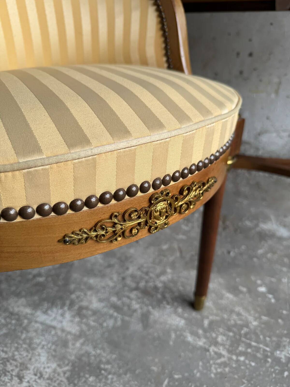 DeCoene antique wood writing desk with beige striped upholstered chair, brass-accented classic set