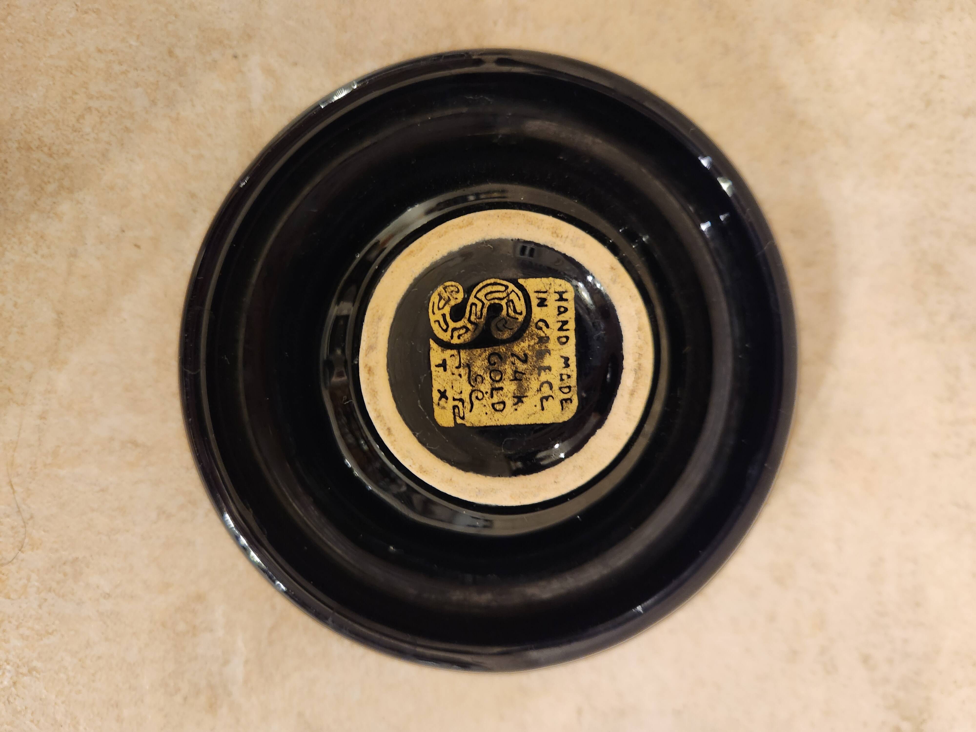 Small vintage ashtray in black ceramic with gold decoration in Greek style.