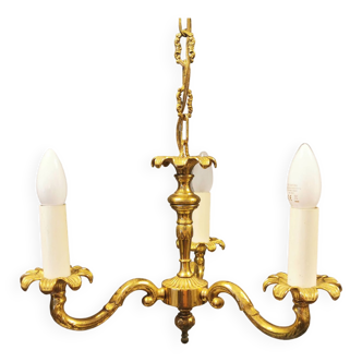 Older brass alloy chandelier with three light sources.