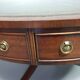 Table basse / table tambour victorienne « Heldense » en acajou avec plateau en cuir sur roulettes en laiton. Années 1980
