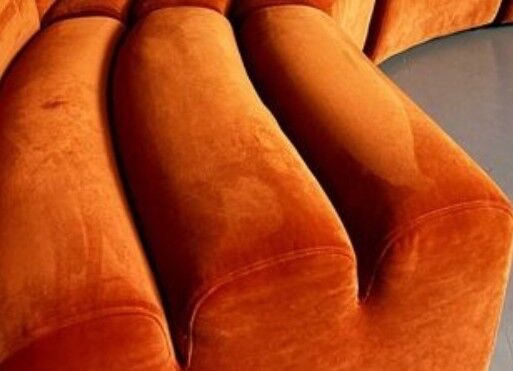 Burnt orange modular sofa for four with a futuristic design.