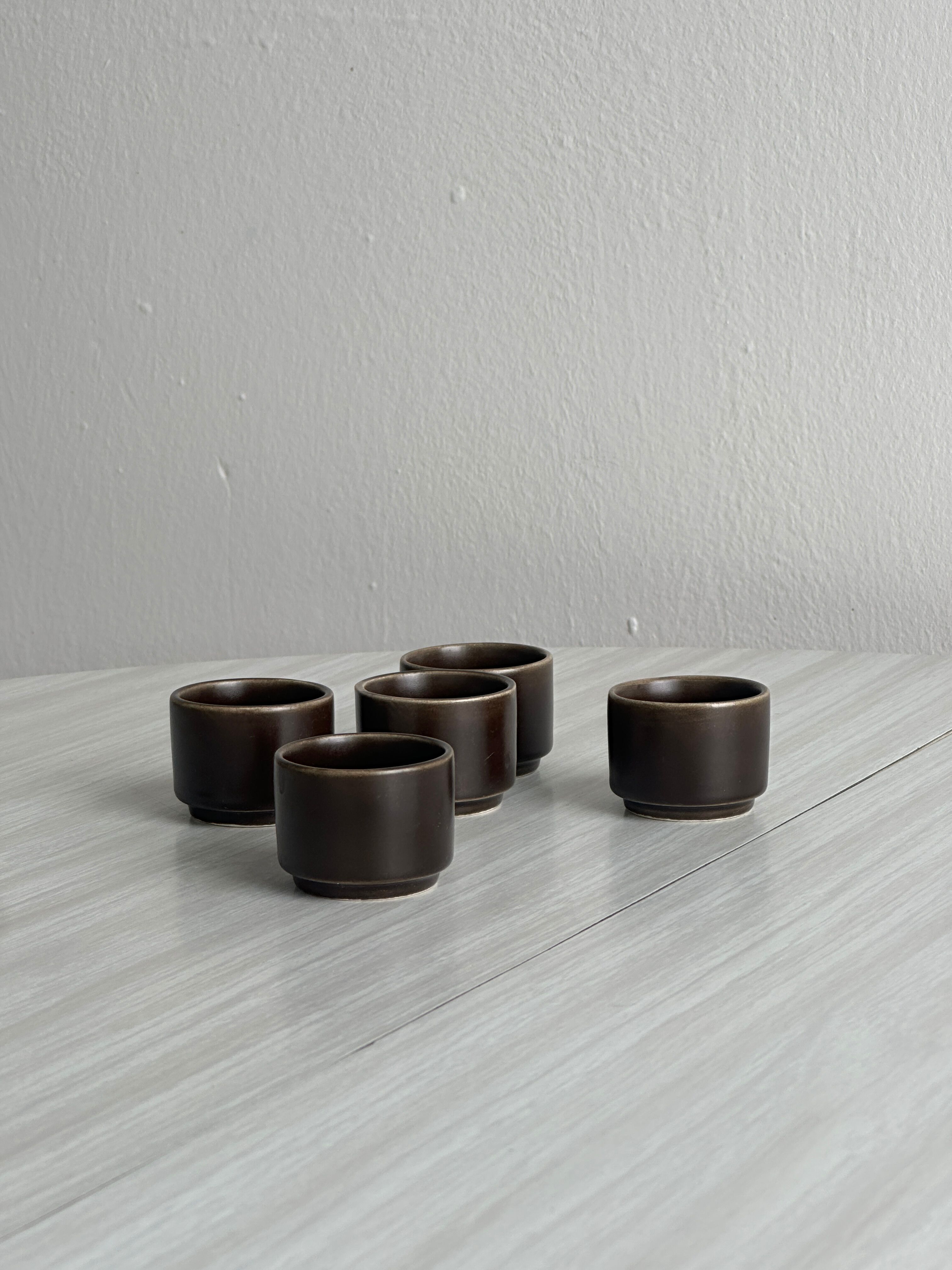 Set of 5 dark brown glazed ceramic egg cups.