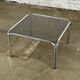 Table basse design vintage en verre fumé avec structure tubulaire