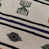 White carpet with multicolored Berber patterns woven hands