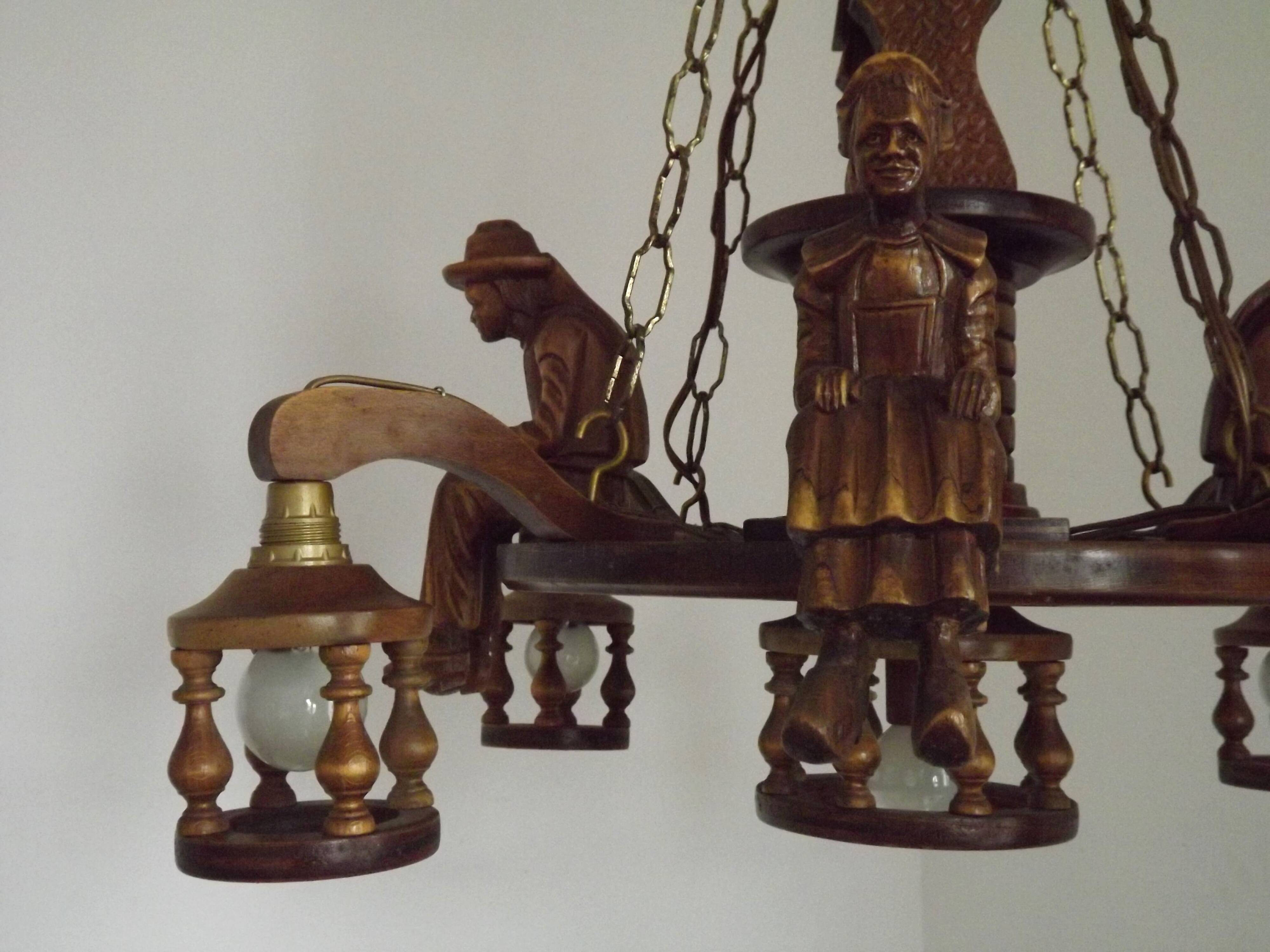 French vintage Breton chandelier with hand-carved figures, well, and lantern lights.