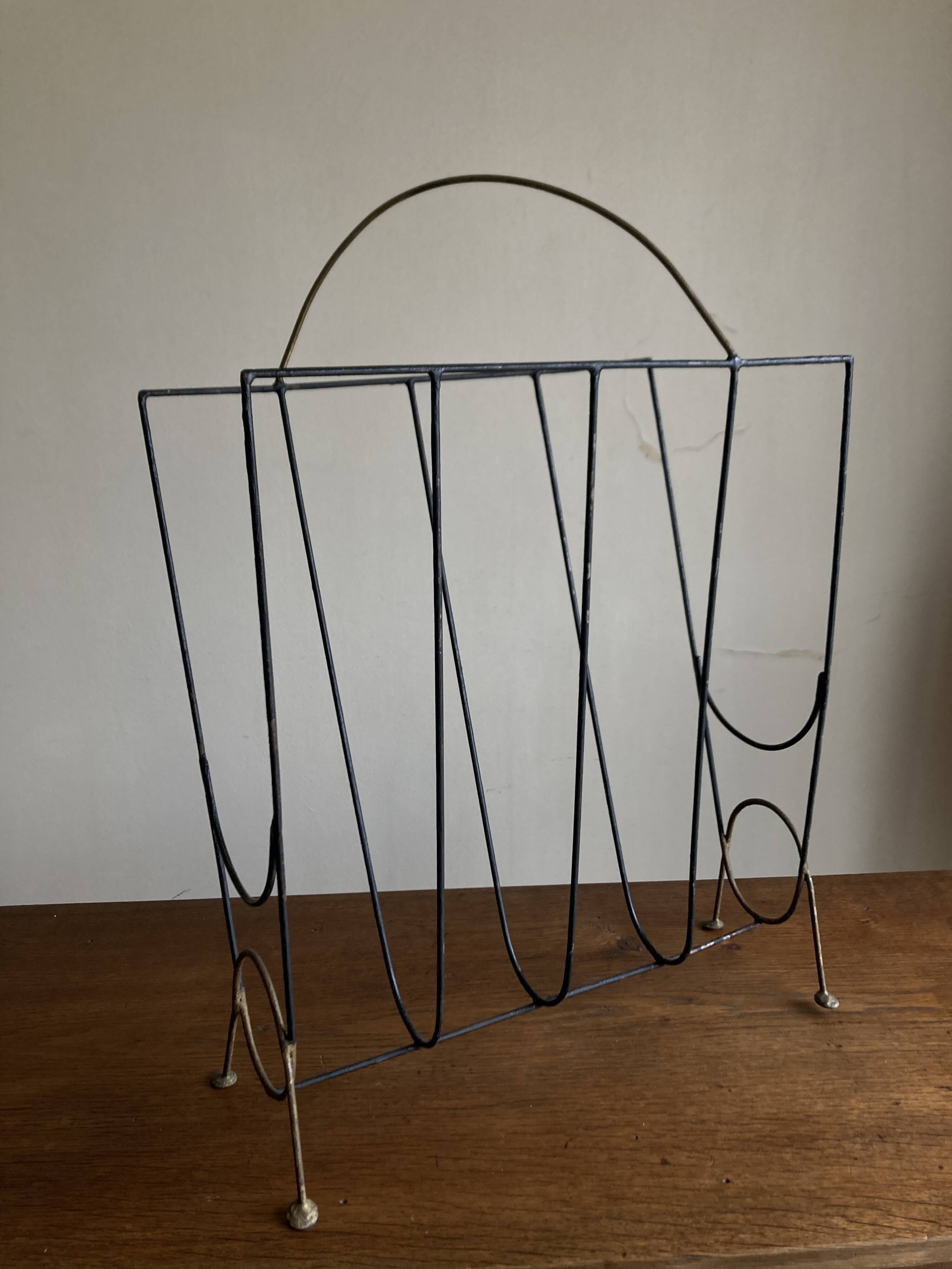 Mid-century poetic magazine rack in black metal