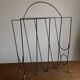 Mid-century poetic magazine rack in black metal