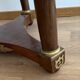 Empire gueridon in mahogany veneer adorned with chiselled and gilded bronze, topped with black marble with a groove.