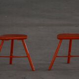 Pair of patinated wooden stools painted red with flared legs, 1950s-1960s.