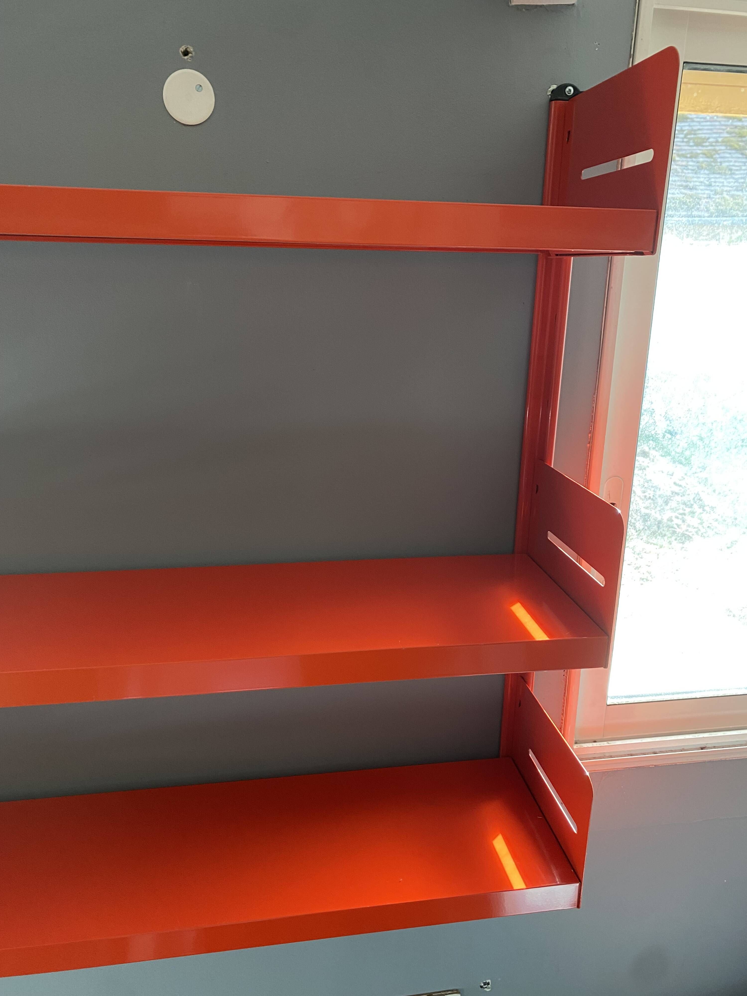 Modular red metal wall shelf in Congresso Lips Vago style.