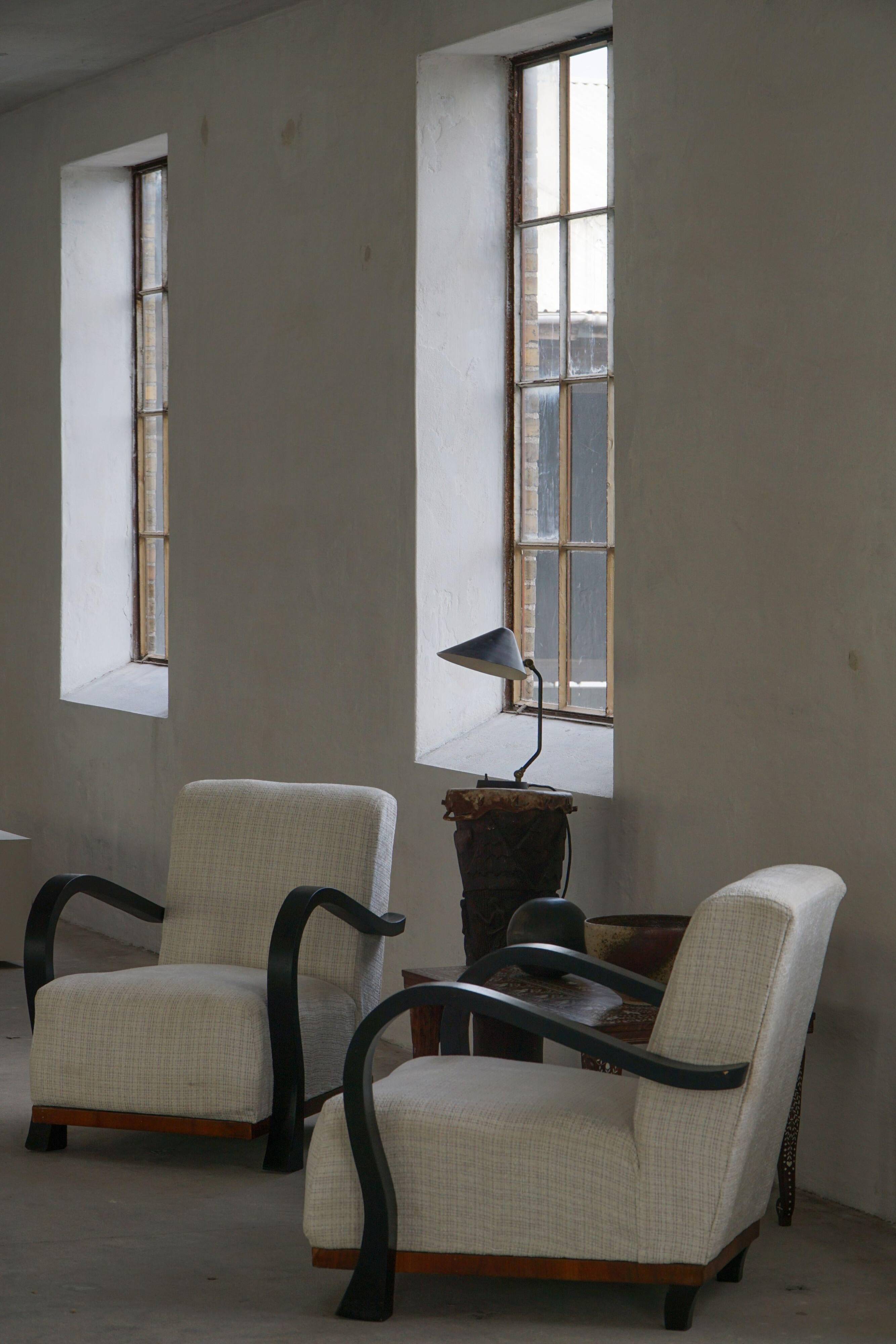 A pair of Swedish Art Deco lounge chairs with curved armrests, 1930s.