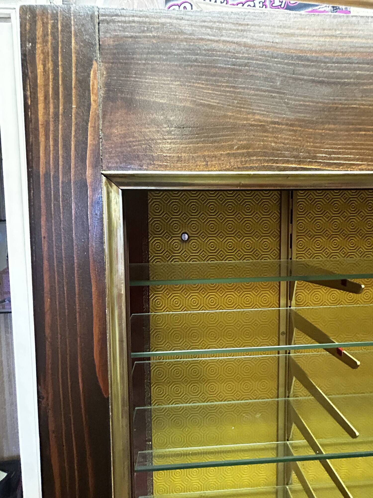 Vintage wooden and glass display cabinet, 15 shelves, gold background.
