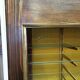 Vintage wooden and glass display cabinet, 15 shelves, gold background.