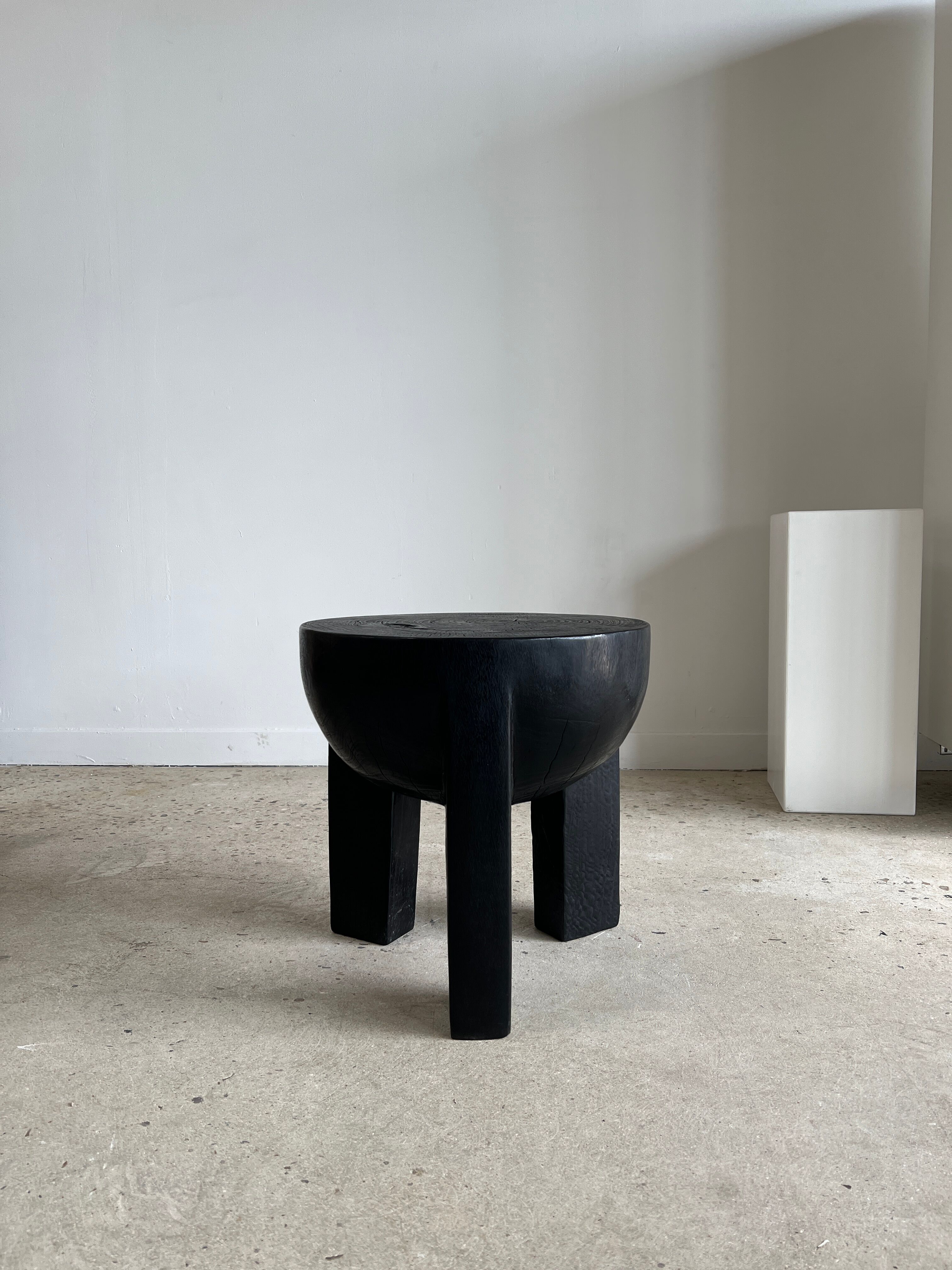 Black mango wood tripod side table with a semi-spherical top, height: 45 cm, diameter: 44 cm.