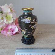 Small black cloisonné vase decorated with yellow and pink cherry blossoms, vase on wooden base