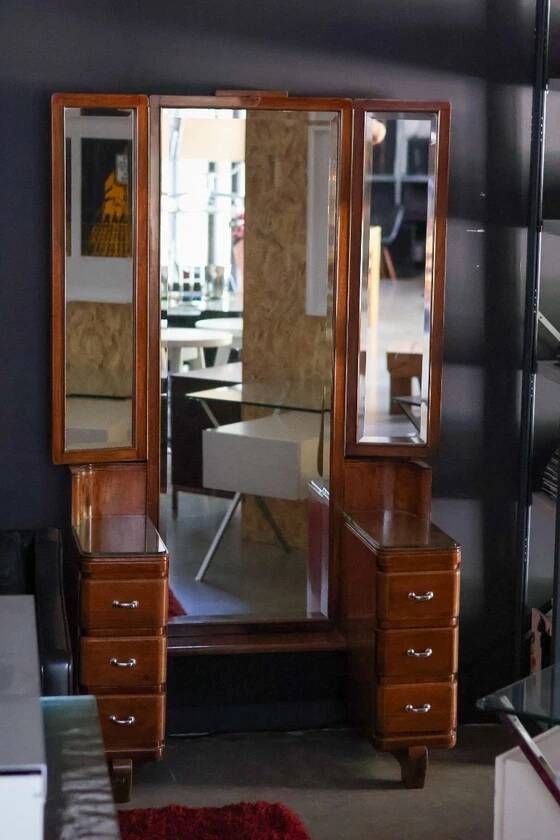 Hairdresser with a large shaped mirror and two pivoting side mirrors.