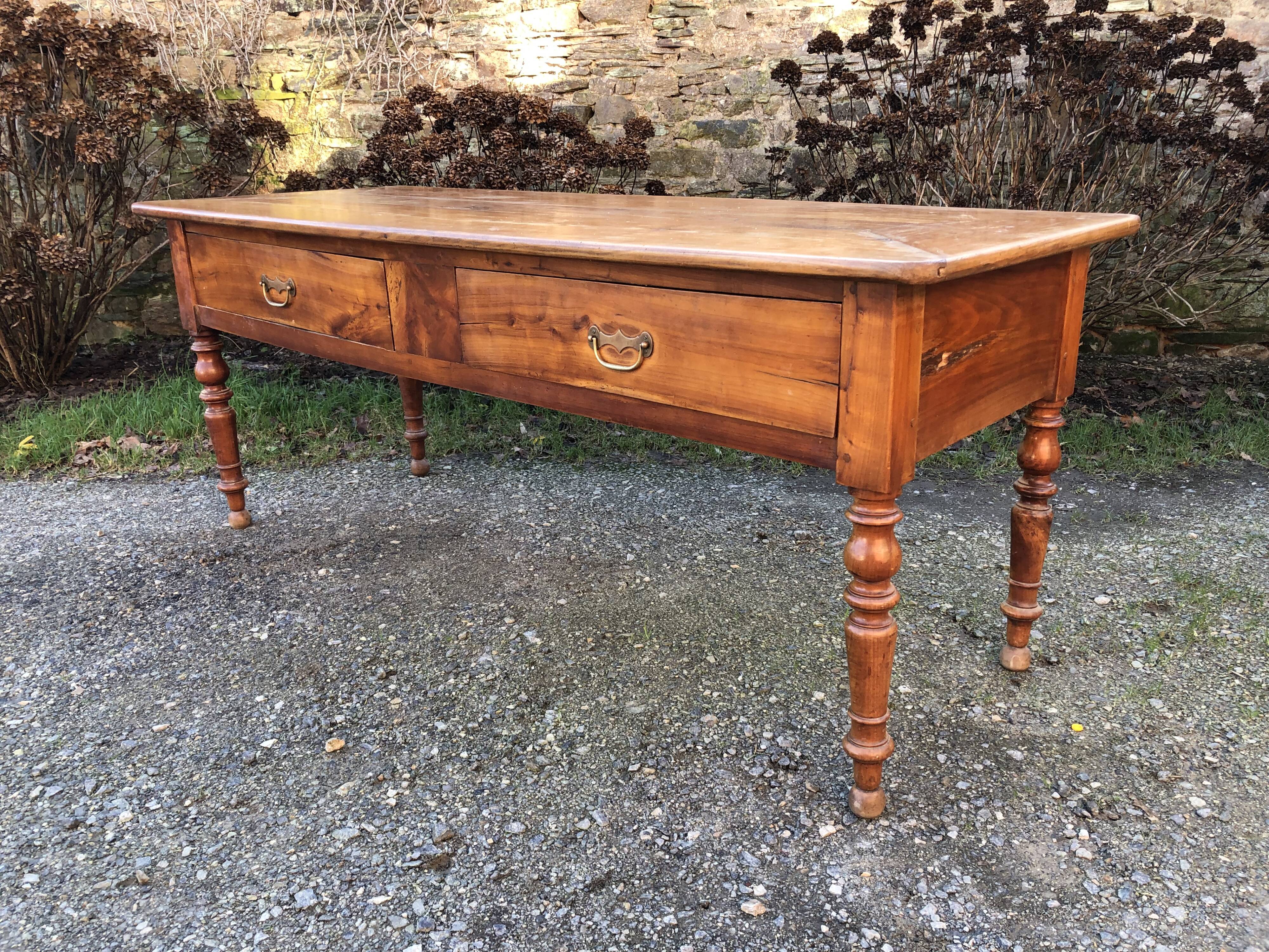 Antique cherry farmhouse table with turned legs and 2 drawers.