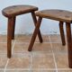 Pair of rustic tripod stools in solid wood, brutalist style.