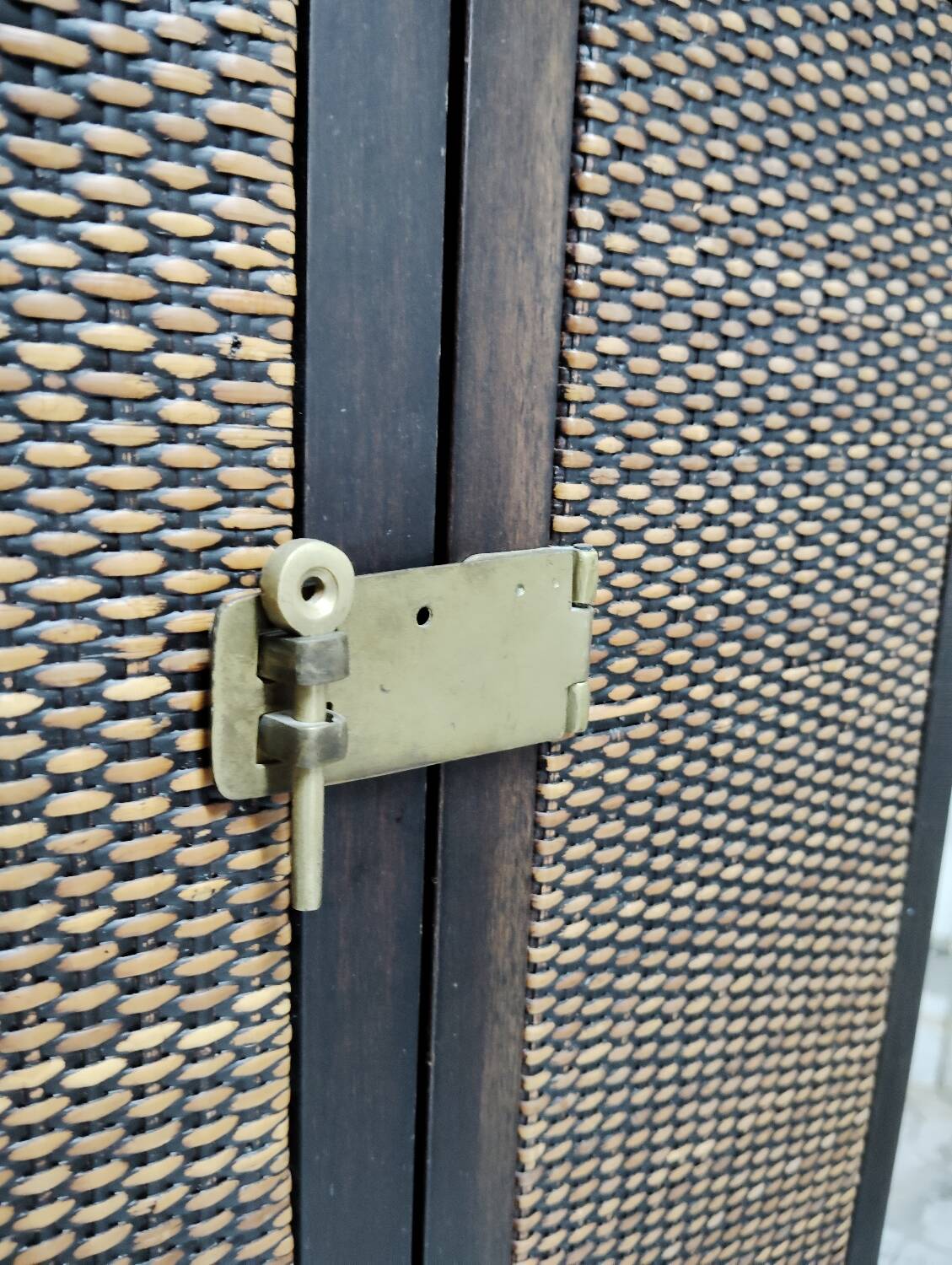 Wardrobe trunk on casters in mahogany and woven rattan.