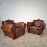 Important pair of Havana leather club armchairs, moustache models, mid-20th century.