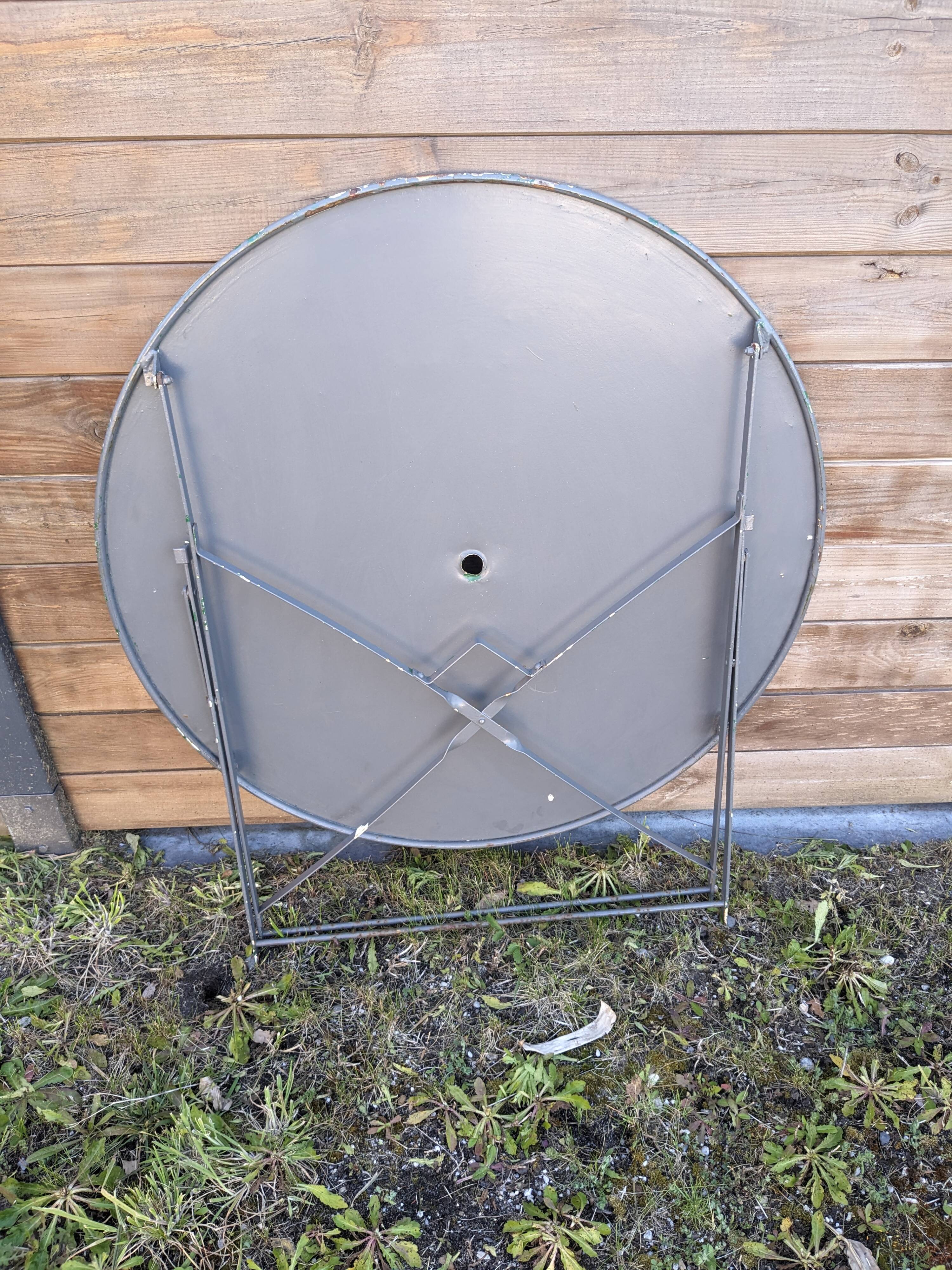 Antique round folding garden table with a green patina.