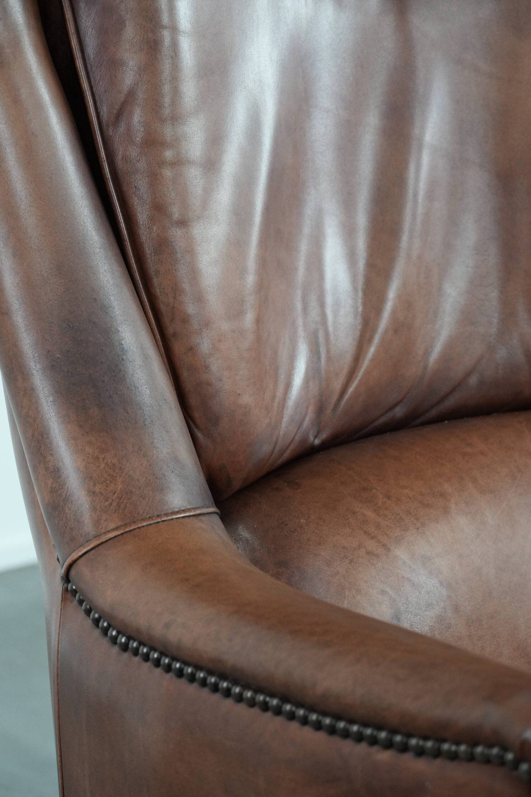 Cognac brown cow leather armchair with decorative nail finish