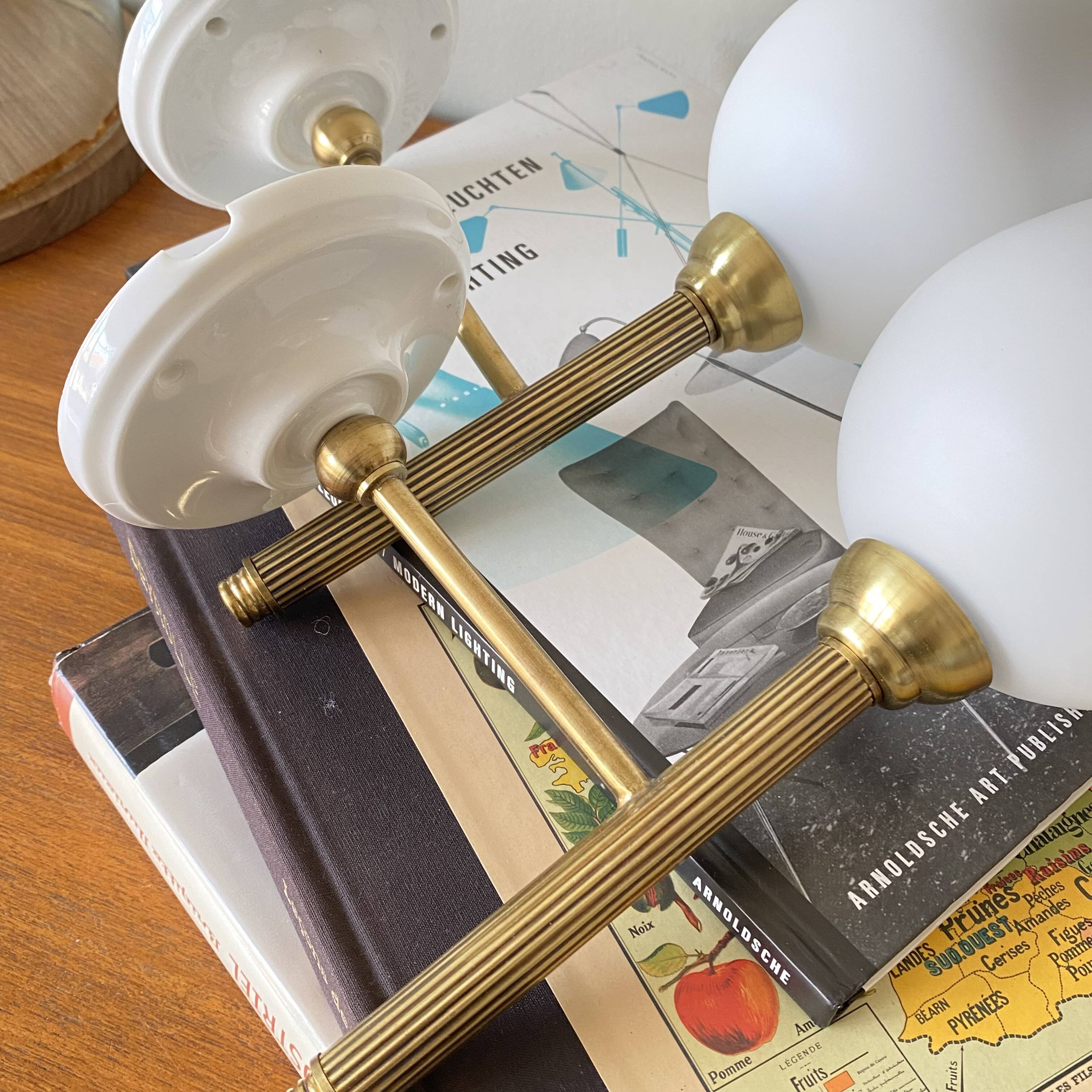 Pair of torch wall lights in brass, white glass and porcelain.