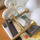 Pair of torch wall lights in brass, white glass and porcelain.