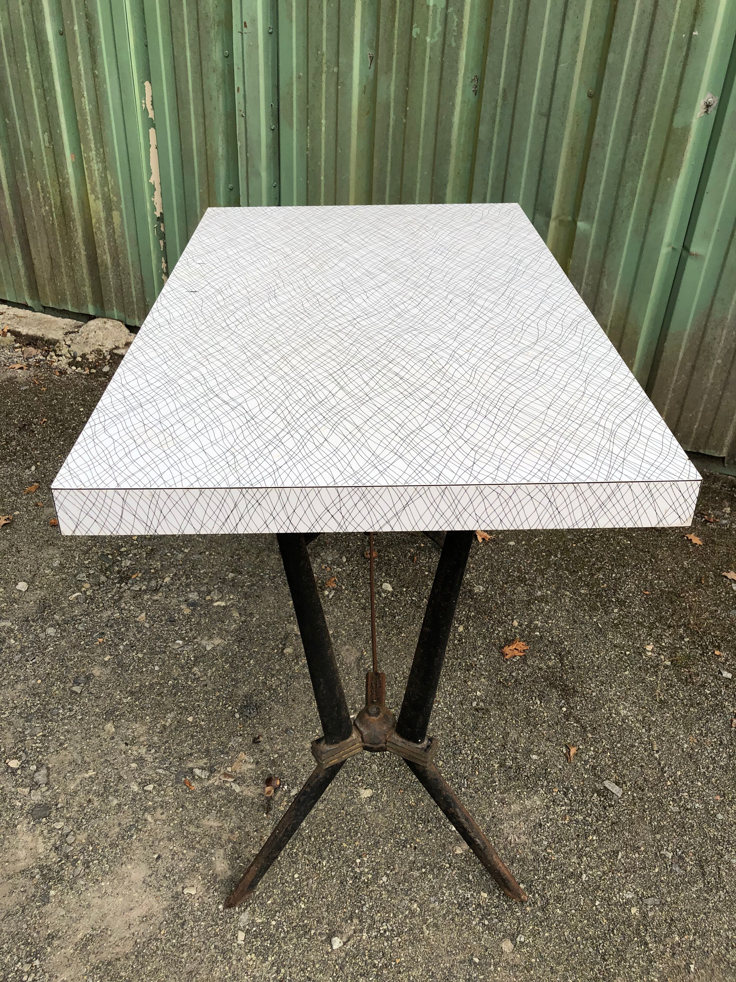 Vintage bistro table with an Art Deco style cast iron base and Formica top.