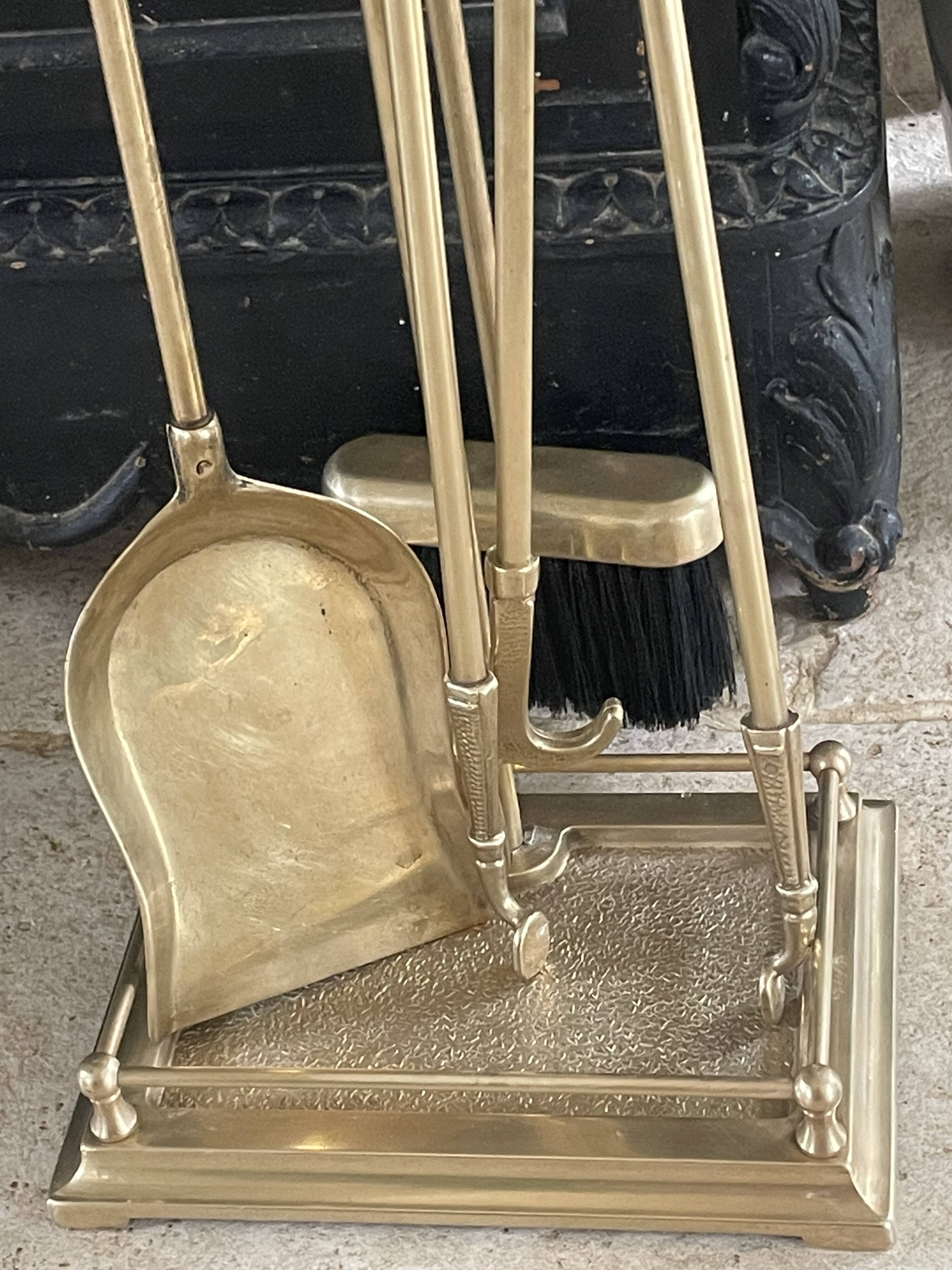 Brass fireplace tools in the style of Maison Baguès.