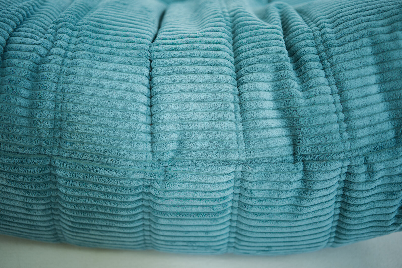 Ensemble de fauteuil et pouf Togo en velours côtelé bleu clair.