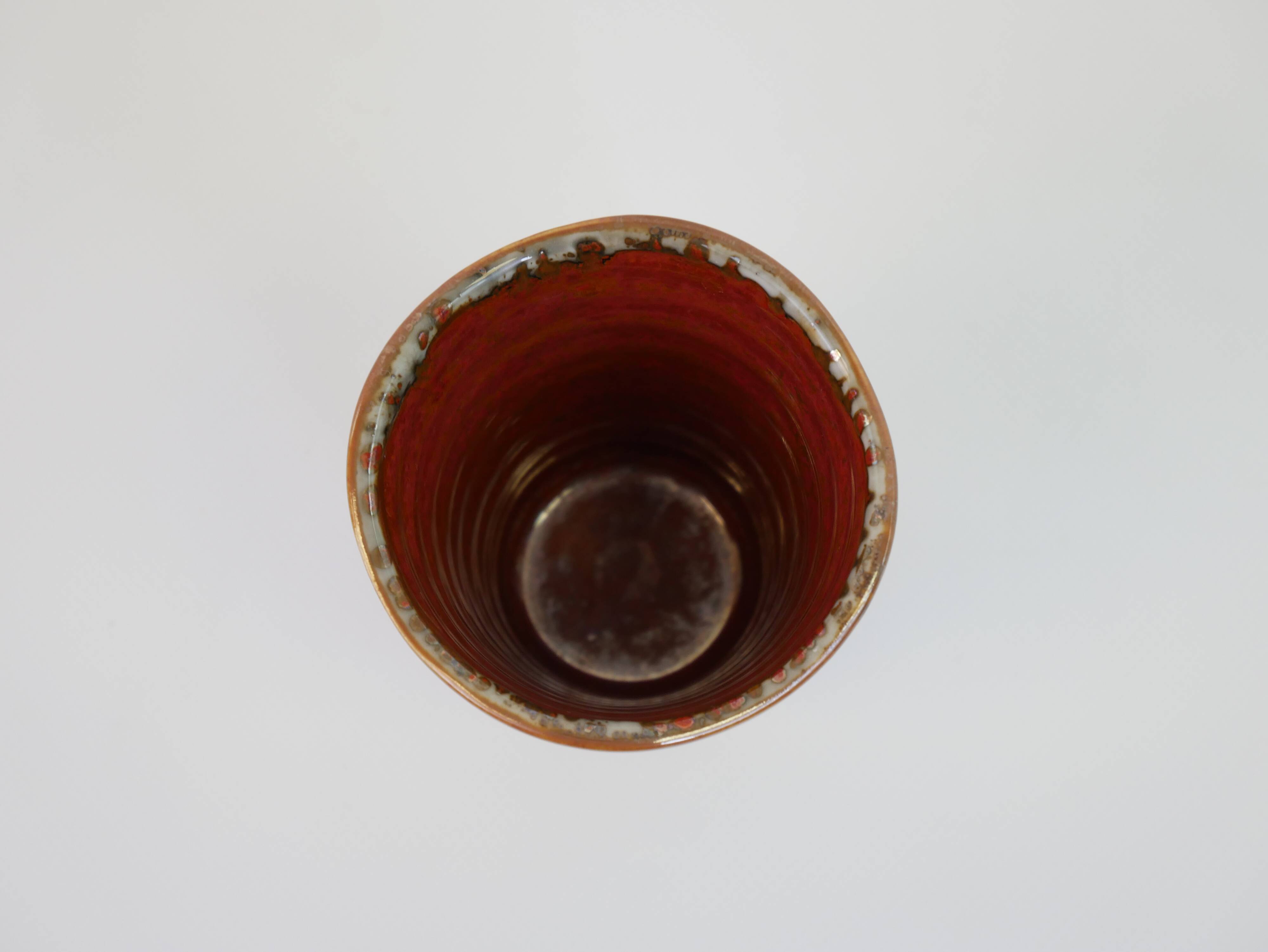 Small orange glazed ceramic cup