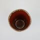 Small orange glazed ceramic cup