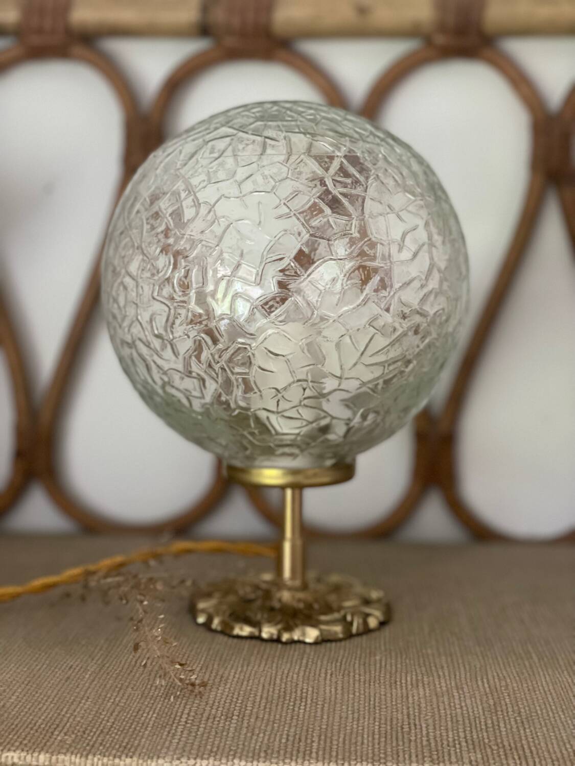 Small handcrafted globe lamp with a cracked finish and a golden brass base.