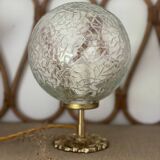 Small handcrafted globe lamp with a cracked finish and a golden brass base.