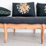 Old bench upholstered in black canvas flowers