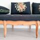 Old bench upholstered in black canvas flowers