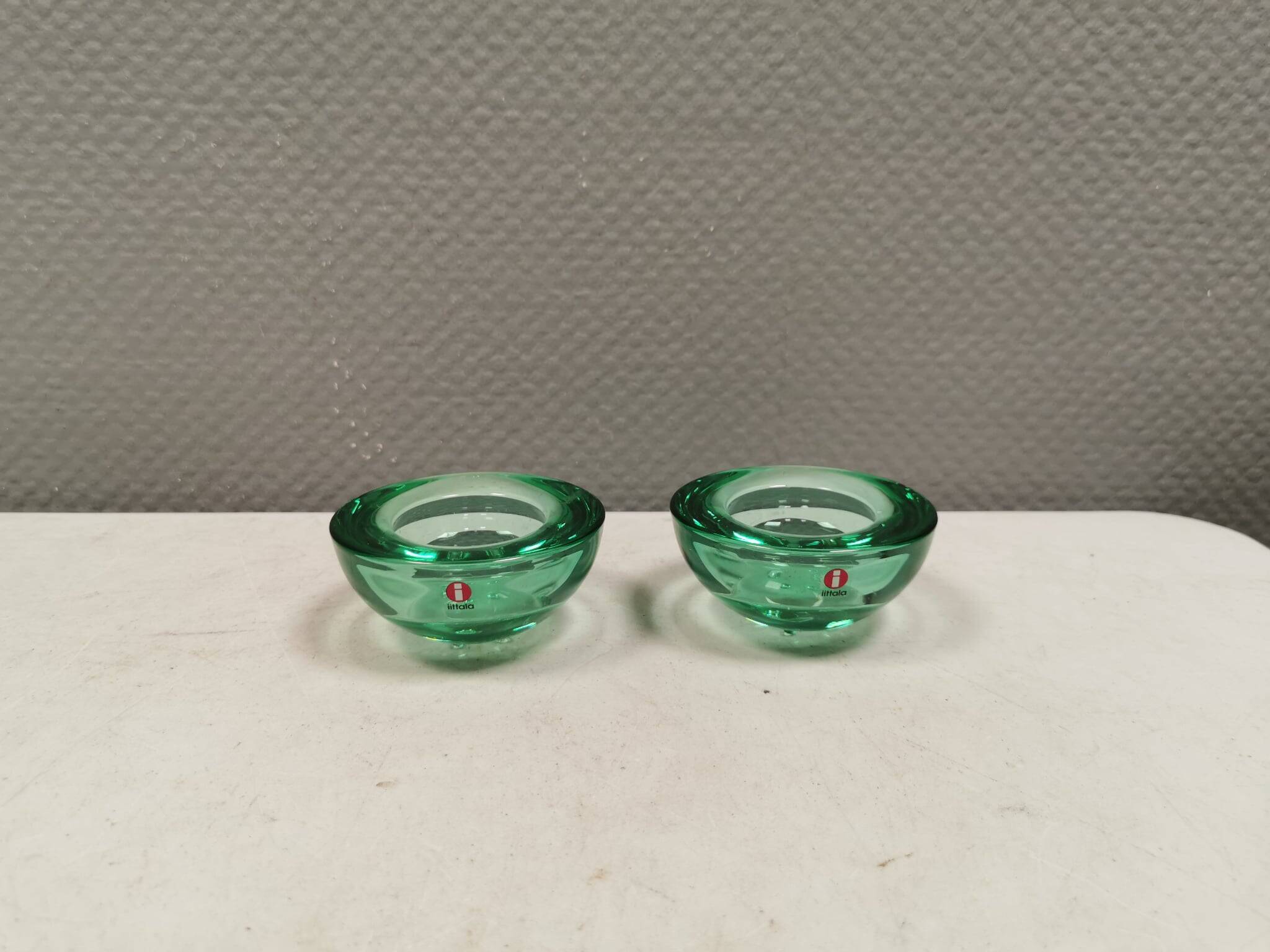 A set of iitalla candle holders in green transparent glass.