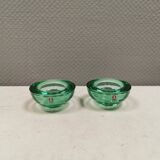 A set of iitalla candle holders in green transparent glass.